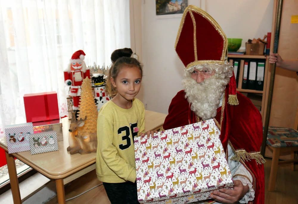 Samantha übergibt dem Nikolaus ein Paket. Vereinsmitglied Jörg Kleindienst steckt in dem Kostüm, mit dem er in den nächsten Wochen oft unterwegs sein wird, um Pakete zu empfangen und zu verteilen.