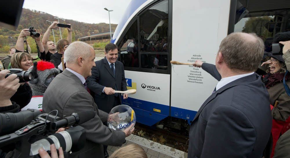 Ein Zug wird durch Verkehrsminister Thomas Webel, Bürgermeister Thomas Balcerowski und Hex-Geschäftsführer Michael Schröder (v.r.) getauft.