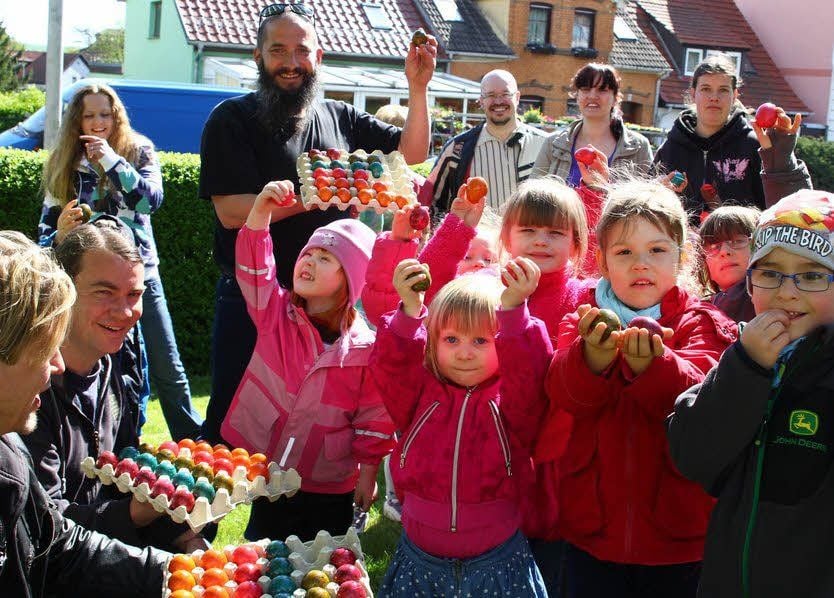 Sven Wittek und Gilbert Rödiger (vorn von links) verteilen gemeinsam mit Jost Naumann (hinten) ihre bunten Eier an Eisleber Kinder.