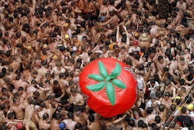 Besucher der «Tomatina» spielen mit einem Tomatenballon. (FOTO: DPA)