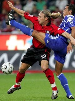 Der Leverkusener Andrej Woronin (l) und der Schalker Dario Rodriguez versuchen an den Ball zu kommen. (Foto: dpa)