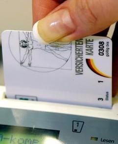 Eine Sprechstundenhilfe schiebt die Versichertenkarte eines Patienten in ein Lesegerät. (Foto: dpa)