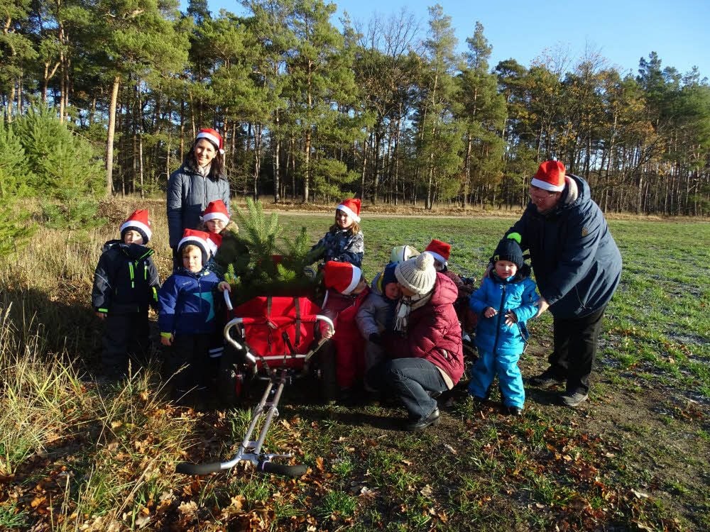 Die Kinder der Dietrichsdorfer Kita, hinten Leiterin Sara Heckendorf, bringen diesmal einen Weihnachtsbaum mit aus dem Wald.