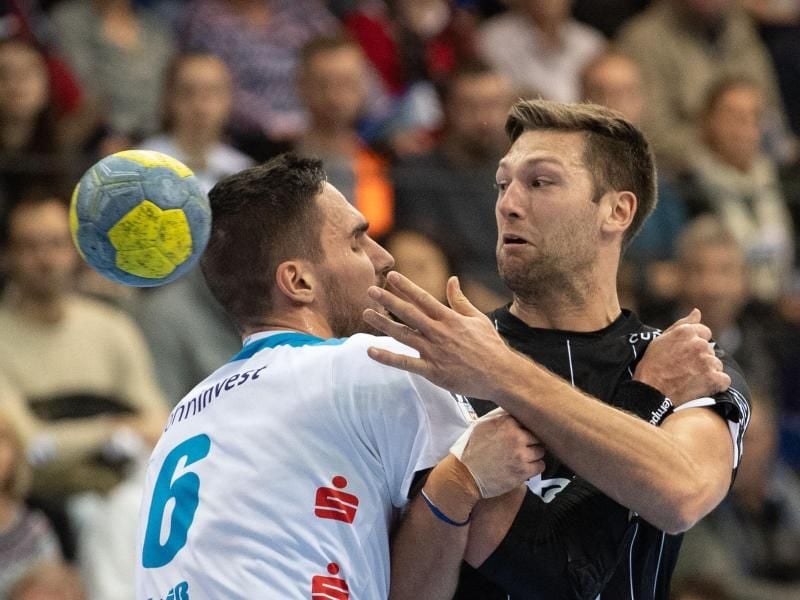 Harald Reinkind (r) vom THW Kiel wird von TVB-Spieler Dominik Weiß gebremst. Foto: Marijan Murat/dpa