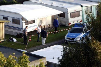 Beamte der Spurensicherung stehen auf einem Campingplatz in Cuxhaven an einer Absperrung.