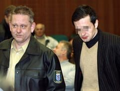 Jens A. (r) wird am Mittwoch (22.02.2006) vor der Urteilsverkündung vom einem Justizbeamten zur Anklagebank im Frankfurter Landgericht geführt. (Foto: dpa)
