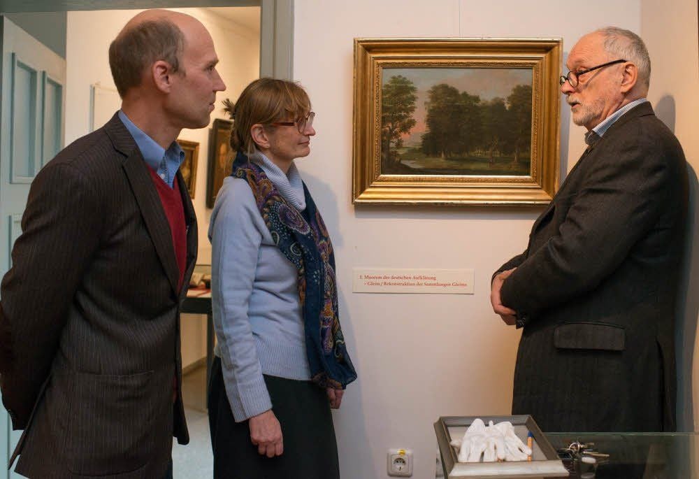 Gleimhaus-Mitarbeiter Reimar Lacher (l.), Direktorin Ute Pott und Jürgen Ostwald von der Fielmann AG betrachten das Landschaftsgemälde von Pascha Johann Friedrich Weitsch. Der jüngste Neuerwerb des Literaturmuseums vervollständigt die aktuelle Sonderausstellung.