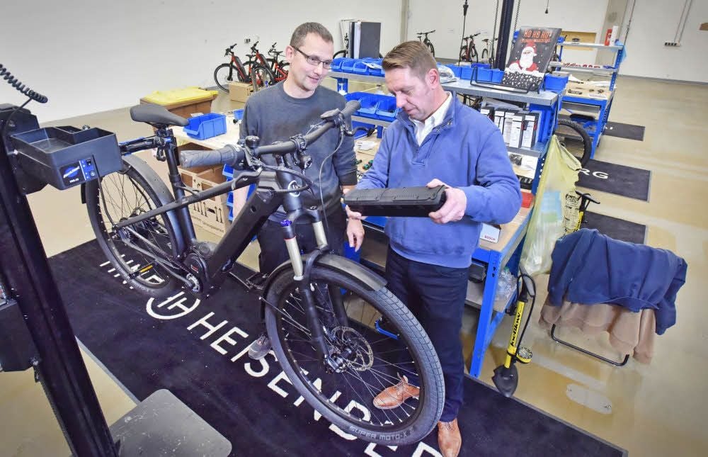 Der Geschäftsführer der HNF Works GmbH, René Daniel (r.), und Zweiradmechaniker Marco Baier demonstrieren, wie ein E-Bike montiert wird.