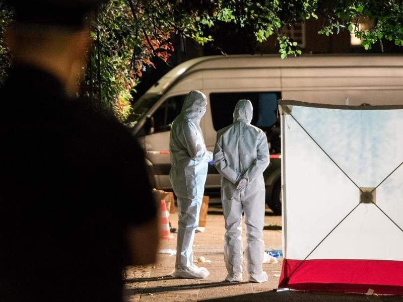 Polizisten in Schutzanzügen untersuchen im Stadtteil Lohbrügge einen Tatort. Foto: Daniel Bockwoldt