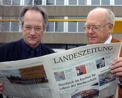 Vor einem Gymnasium in Lüneburg lesen der Direktor Horst Homburg (r.) und sein Stellvertreter Hans-Christian Höhne am Donnerstag (12.02.2004) in einer Regionalzeitung. Nach dem Verzehr eines Schokoladenkuchens, der von Unbekannten vor dem Lehrerzimmer abgestellt worden war, hatten zehn Lehrer am Mittwoch unter Zittern, Unwohlsein und Wahrnehmungsstörungen gelitten. Es bestand Verdacht auf Haschisch-Vergiftung. Die Polizei teilte nach Untersuchungen der Kuchenreste jetzt mit, dass definitiv Cannabis beigemischt war. (Foto: dpa)
