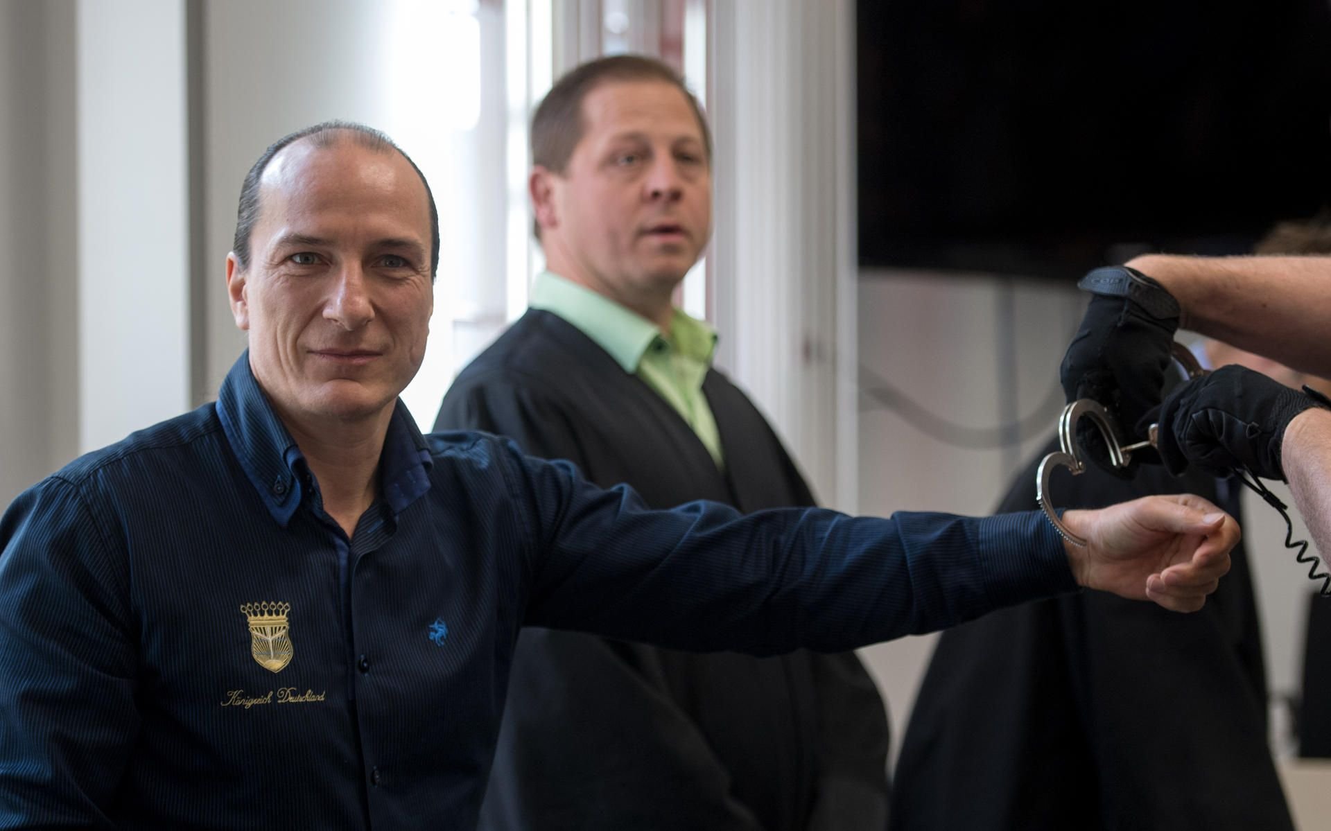 Der selbst ernannte "König von Deutschland", Peter Fitzek (l.) bekommt im Landgericht in Halle die Handschellen abgenommen.