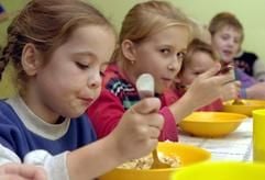 Gemeinsam mit anderen polnischen Kindern nimmt Kasia (l) in der Kirche «Heilige Maria - Königin Polens» in Slubice ihr Abendbrot ein (Archivfoto vom 18.10.2001). Viele Kinder in Polen sind auf Schulspeisungen angewiesen, um wenigstens einmal pro Tag eine warme Mahlzeit zu bekommen. Der Beginn des neuen Schuljahres Anfang September wird deshalb von vielen Kindern herbeigesehnt - denn während der Sommerferien müssen sie oft hungrig bleiben. (Foto: dpa)