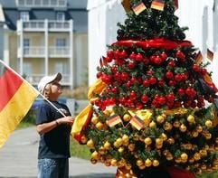 Ein junger Fußballfan schaut am Donnerstag (17.08.2006) auf die neueste Kreation der südthüringischen Glasschmuckfirma Krebs Glas aus Lauscha, einem Weihnachtsbaum in den Farben Schwarz-Rot-Gold. (Foto: dpa)