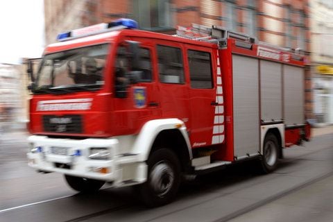 Ein Löschfahrzeug der Feuerwehr ist mit Blaulicht und Signalhorn unterwegs. (FOTO: DPA)