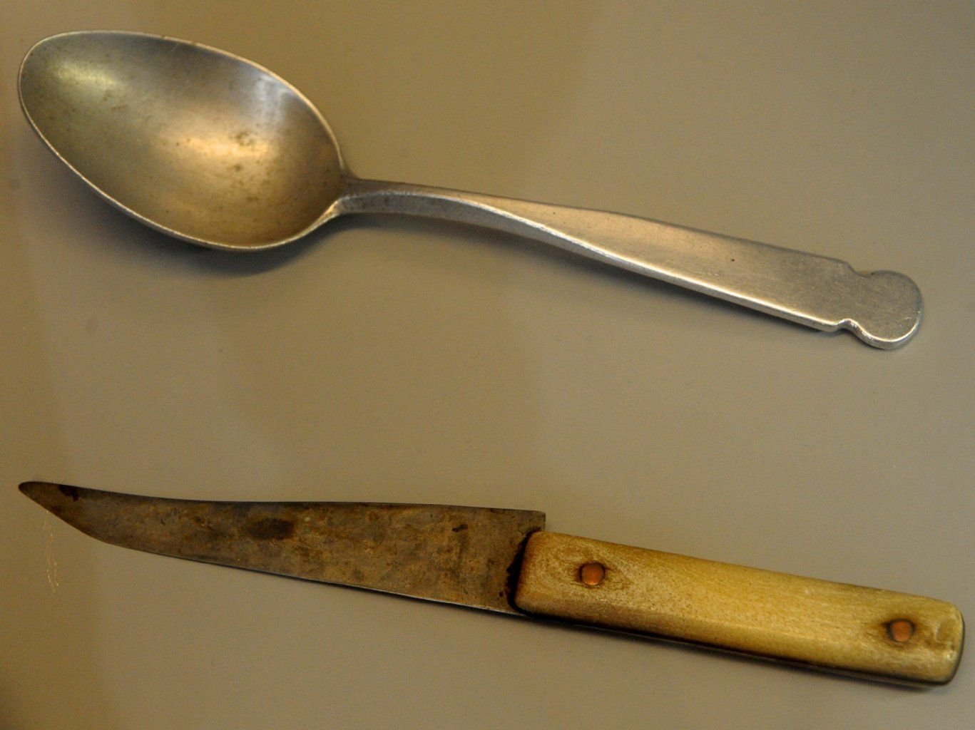 Ein originaler selbstgefertigter Löffel (oben) und ein selbstgefertigtes Messer mit knöchernem Griff (unten), die von sowjetischen Strafgefangenen hergestellt und verwendet wurden, sind am 11.03.2014 in der Ausstellung "Gulag.