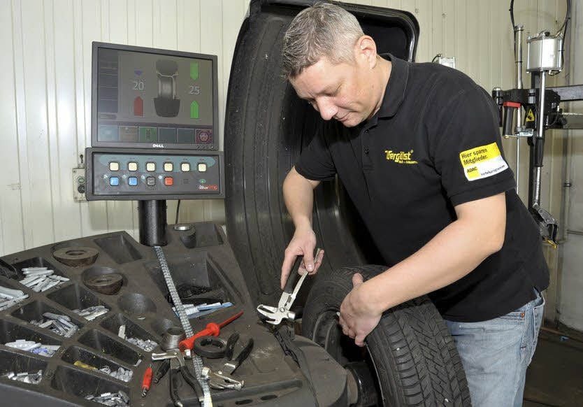 Bei Vergölst in Bernburg werden Termine vergeben. Kfz-Meister Andreas Trostdorf bringt beim Auswuchten Metallgewichte an einer Felge an.