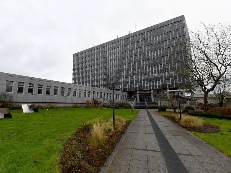 Blick auf den Eingang zum Kraftfahrt-Bundesamt in Flensburg. Nur noch etwa 20 Prozent der Vorgänge lagern hier als Akten, der Großteil ist auf Datenträgern gespeichert. Foto: Carsten Rehder/dpa