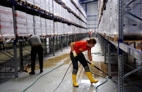 Mitarbeiter der Fit GmbH im ostsächsischen Hirschfelde reinigen im neuen Hochlager den Fußboden vom Dreck des Hochwassers der Neiße. (FOTO: DDP)