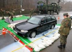 Vor dem Rügendamm fährt am Sonntag (19.02.2006) ein Pkw über Seuchenschutzmatten, die von einer ABC-Spezialeinheit der Bundeswehr aus Prenzlau ausgelegt werden. Die Seuchenschutzmatten sollen die Weiterverbreitung des gefährlichen Vogelgrippevirus verhindern helfen. (Foto: dpa)