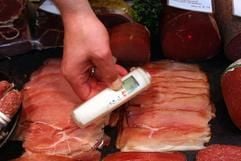 Ein Lebensmittelkontrolleur misst in einer Fleischerei die Temperatur von Wurst. (Foto: ddp)