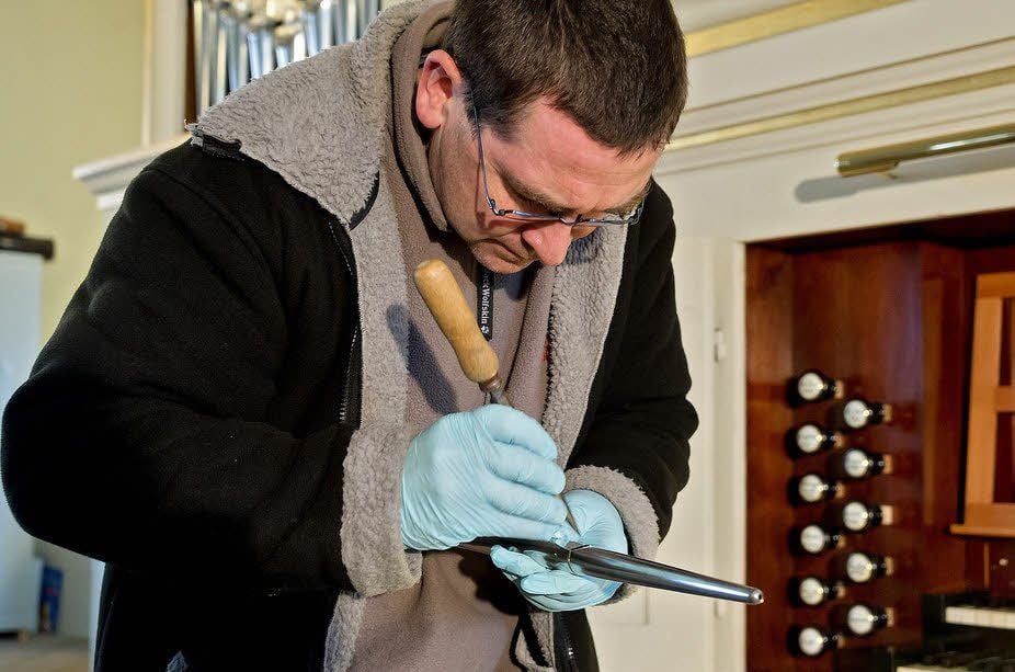 Während Tino Herrig am Klang der Pfeifen feilt, schleppt Gunnar Schmid die riesigen Holzpfeifen in die Kirche.