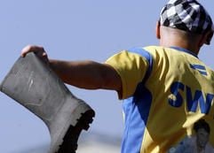 Weit holt ein schwedischer Sportler bei der Gummistiefelweitwurf-WM in Berlin aus, bevor er seinen Gummistiefel über das Feld wirft. (Foto: dpa)