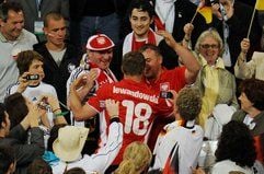 Deutsch-polnisches Freudenfest: Lukas Podolski umarmt nach dem Spiel im Trikot des polnischen Spielers Mariusz Lewandowski seine polnischen Verwandten. (Foto: dpa)