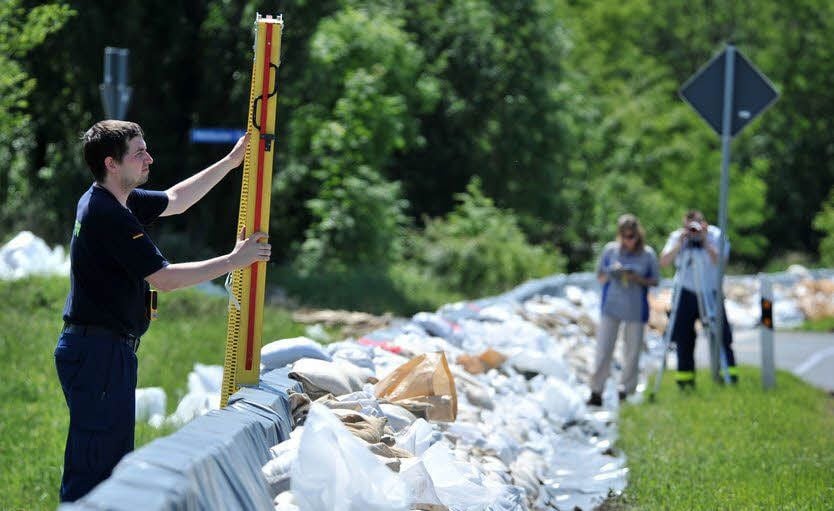Mitarbeiter des Technischen Hilfswerkes bestimmen die Sandsackhöhe.