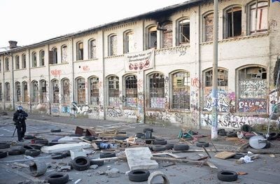 Ein Polizist geht am Donnerstag in Erfurt vor dem Gelände des besetzten Gebäudes der ehemaligen Firma «Topf & Söhne» entlang. (FOTO: DDP)