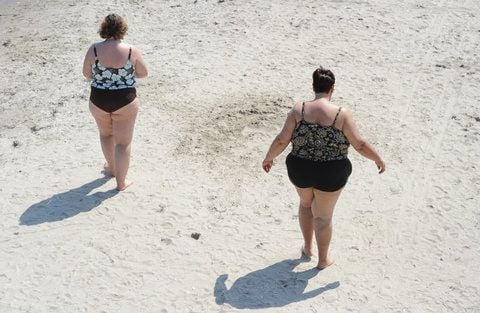 Zwei übergewichtige Frauen spazieren an einem Strand entlang. (FOTO: DPA)