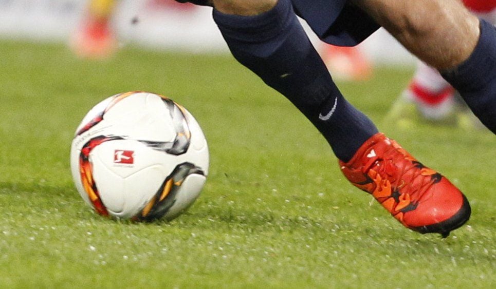 Ein Fußballer führt das Spielgerät eng am Fuß.