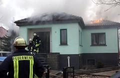 Feuerwehrmänner sind in Zerbst an einem Einfamilienhaus im Einsatz, in dem es am Freitag (21.02.2003) zu einer Gasexplosion gekommen war. (Foto: dpa)
