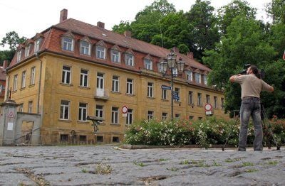 Ein Kameramann filmt die Reuß-Häuser am Mohrenplatz in Gera: Das Fürstenhaus Reuß fordert eine Wiederaufnahme des Verfahrens zur Rückübertragung mehrerer Immobilien im Geraer Stadtteil Untermhaus. (Foto: dpa)