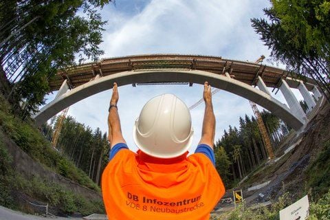 Ein Mitarbeiter der Deutschen Bahn zeigt am Montag vor der Dunkeltalbrücke bei Goldisthal die Breite des noch für den Lückenschluss zu betonierenden Stücks. (FOTO: DPA)