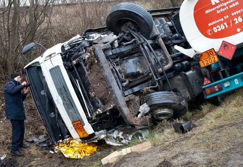 Ein Polizist fotografiert am Mittwoch den bei einem Unfall bei Straußfurt zerstörten Tanklaster. (FOTO: DPA)