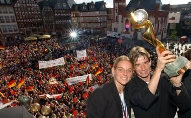Die deutschen Fußball-Frauen Nia Künzer und Bettina Wiegmann (r) halten auf dem Balkon des Römers den Pokal hoch. Nach ihrer Rückkehr aus den USA wurde die Mannschaft am Dienstag (14.10.2003) am Frankfurter Römer von einer begeisterten Menschenmenge empfangen. (Foto: dpa)