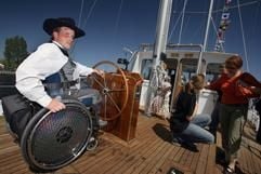 Der Rollstuhlfahrer Oke Lass demonstriert am Samstag (05.05.2007) an Bord des Segelschiffs «Wappen von Ueckermünde» im Hafen von Ueckermünde am Stettiner Haff die Bedienung des Steuerrads. (Foto: dpa)