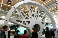 Vor dem Statorteil einer Windkraftanlage stehen Besucher auf der Hannover Messe in der niedersächsischen Landeshauptstadt. Insgesamt zeigen vom 11. bis zum 15. April 2005 rund 6 100 Aussteller aus 65 Nationen bihre Produkte. (Foto: dpa)