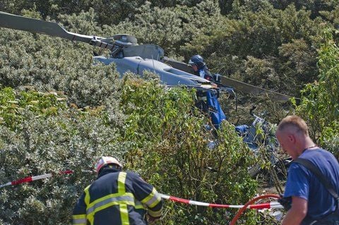Rettungskräfte stehen neben Dem Wrack eines Helikopters, der im Rotterdamer Hafen abgestürzt ist. (FOTO: DPA)