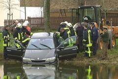 Feuerwehrleute und Mitarbeiter von DLRG bergen ein Auto aus dem Teich in Spickendorf. (MZ-Foto: Chris Wohlfeld)