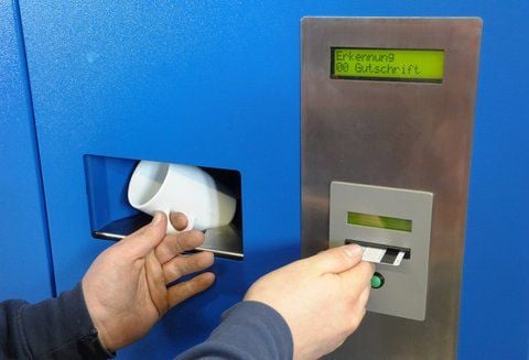 Eine Tasse wird in einen Tassenrücknahmeautomaten der Firma Loetec GmbH Wittenberg zur Rückgabe gesteckt. (FOTO: DPA)