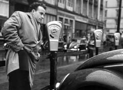 Ein Autofahrer sucht im Jahr 1954 in Hamburg nach einem Parkgroschen. Im Jahr 1954 wurden in Deutschland die Parkuhren eingeführt. Eine Stunde parken kostete einen Groschen, für zwei Stunden müssen 20 Pfennig eingeworfen werden. (Foto: dpa)