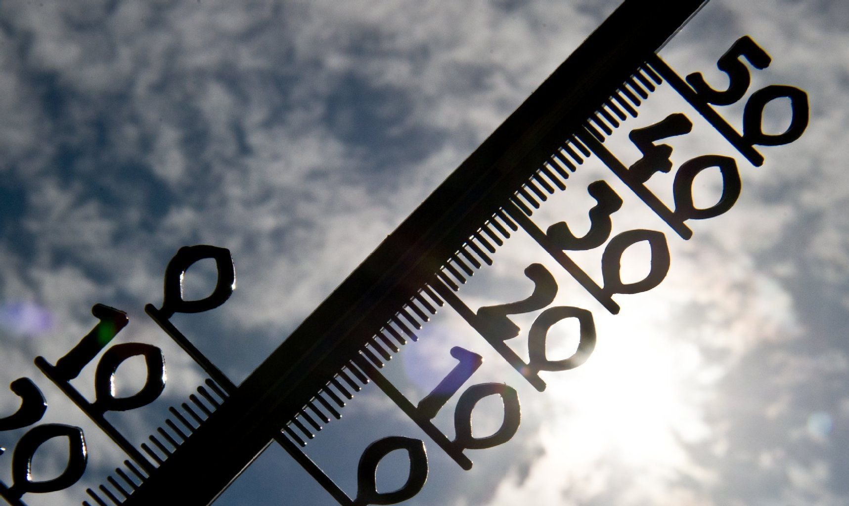 Ein Thermometer wird in Berlin vor die Sonne gehalten.
