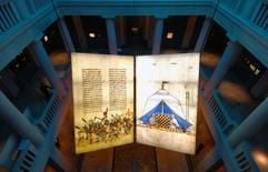 Ein überdimensionales Buch mit Abbildungen des kriegerischen (l.) und des friedlichen Verhaltens der Kreuzritter hängt im Lichthof des Landesmuseums für Vorgeschichte in Halle (Saale), aufgenommen am Mittwoch (19.10.2005). (Foto: dpa)