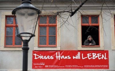 Claus-Peter Neumann, Projektleiter der Deutschen Stadt- und Grundstücksentwicklungsgesellschaft mbH, schaut aus einem leerstehenden Haus in der Naumburger Altstadt, aufgenommen am 20.01.2009 in Naumburg (Burgenlandkreis). An der Fassade ist ein Transparent mit der Aufschrift «Dieses Haus will leben» angebracht. Die Gesellschaft hat zusammen mit der Stadt Naumburg eine neue Verkaufsaktion für sanierungsbedürftige Häuser in der Altstadt gestartet. (FOTO: DPA)