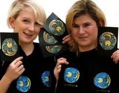 Marie Huber (l) und Andrea Hörentrup vom Landesmuseum für Vorgeschichte in Halle präsentieren T-Shirts und Postkarten mit der "Himmelsscheibe von Nebra". Mit dem heutigen Tag beginnt die Vermarktung des sensationellen Jahrhundertfundes, einer grünlich schimmernden Bronzescheibe mit der ältesten konkreten astronomischen Sternenabbildung der Welt. Raubgräber hatten das prähistorische Stück am 4. Juli 1999 auf dem 252 Meter hohen Mittelberg im Landkreis Merseburg-Querfurt entdeckt. Die Polizei konnte die Scheibe am 23. Februar 2002 bei einer fingierten Verkaufsaktion in der Schweiz sicher stellen. (Foto: dpa)
