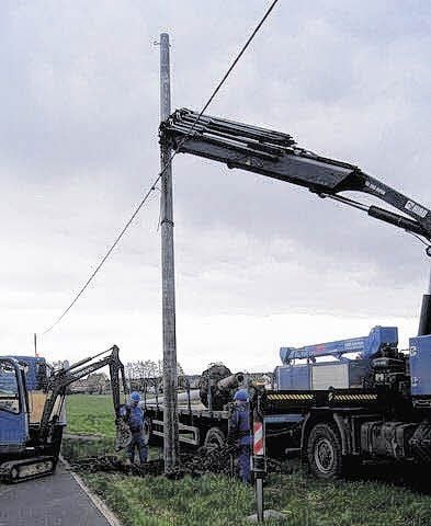 Mitarbeiter der Firma Haupt aus Audenhain wechseln den Leitungsmast.