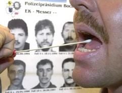 Ein Polizeibeamter nimmt eine Speichelprobe für einen Gentest. (Foto: dpa)