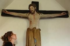 Eine Frau betrachtet am Freitag (05.05.2006) in der Dorfkirche im oberbayerischen Enghausen (Landkreis Freising) das älteste lebensgroße Kruzifix der Welt. (Foto: dpa)