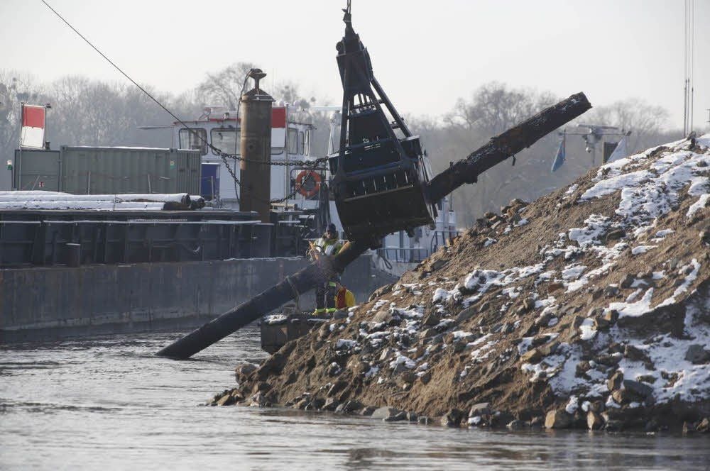 Eine Baggerschaufel hebt die Rohre aus der Elbe, sie werden Stück für Stück durchtrennt.